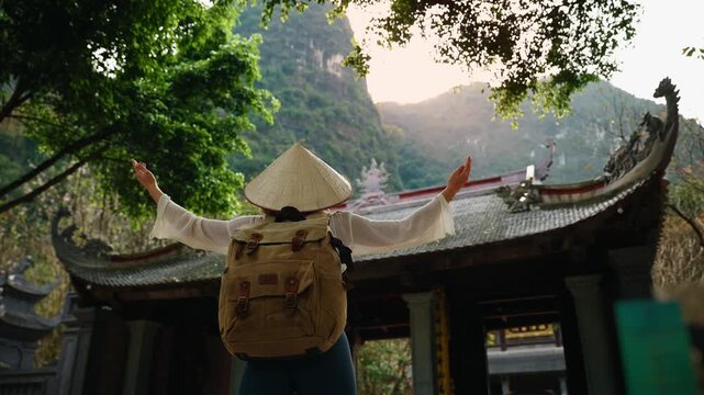 Female traveler in Ninh Binh, Vietnam exploring traditional architecture and scenic beauty. Tam Coc National Park travel trip.