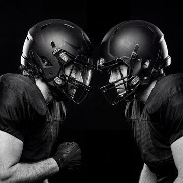 Two football players in intense helmet to helmet face-off black and white portrait