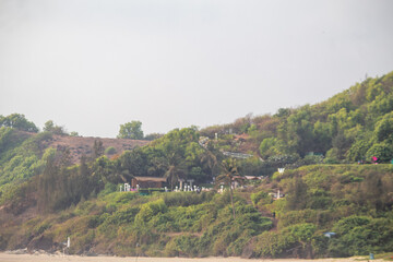 Fototapeta premium Crowded Vagator Beach in Goa India with Tourists Enjoying the Arabian Sea