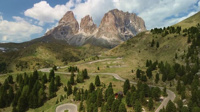 Winding mountain road through alpine valley with dramatic peaks