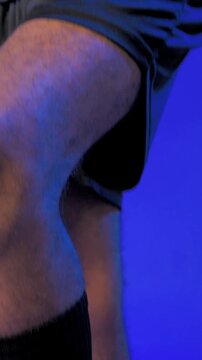 Vertical video: Pressing cleat, soccer player starting pan up in studio showing ball control, glove