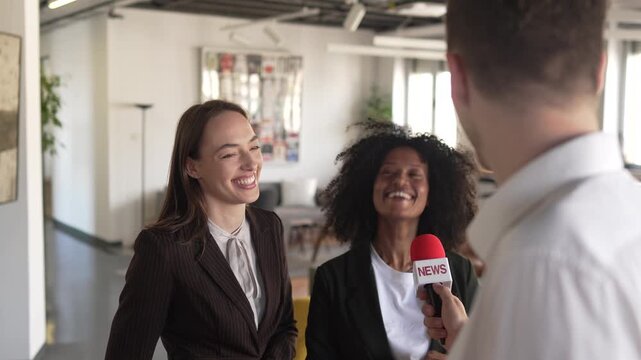 Two female business executives giving an interview to a journalist