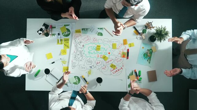 Top view of business team working together to brainstorm environmental idea by using mind map. Aerial view of smart manager talking and putting hands together or making stack of hand. Alimentation.