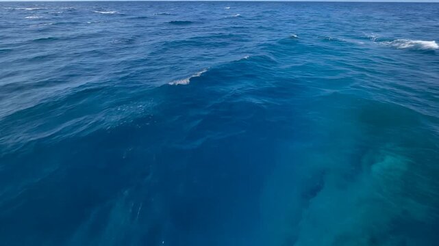 Epic POV flying high above a deep ocean trench with beautiful sapphire blue water gradient