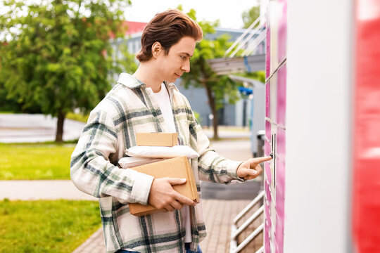 a man holding packages uses an automated parcel locker terminal for a contactless delivery pickup, highlighting modern logistics and ecommerce online shopping.