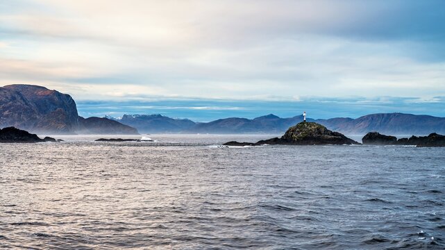 Landscape in Norway with a small lighthouse, seen from a big ship