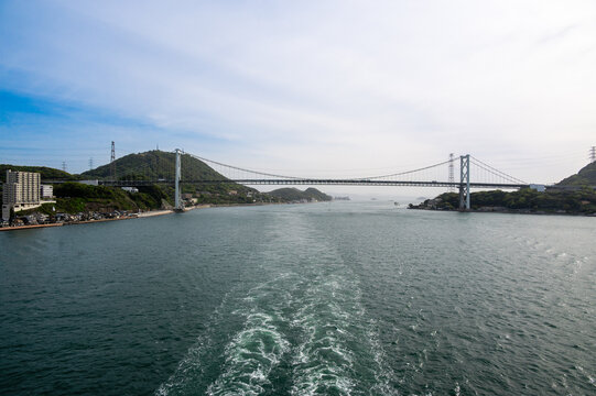 Large suspension Kanmon Bridge over the Kanmon Straits viewed from a cruise ship stern, Japan