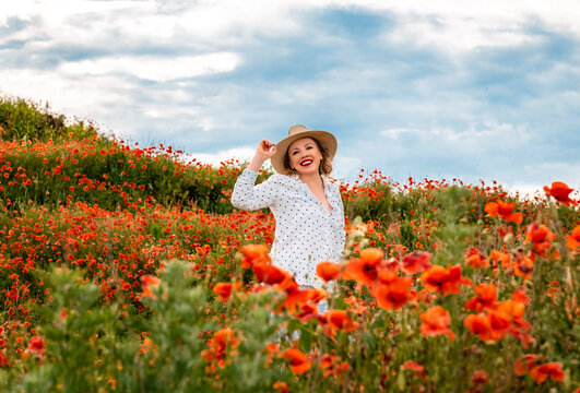 Radiant woman laughs inside crimson floral expanse. Joyous mood, bright summer freshness.