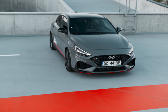 Hyundai i30 N stands on a gray concrete surface with an orange section in an urban setting under daylight  Katowice, Poland, 19.06.2021
