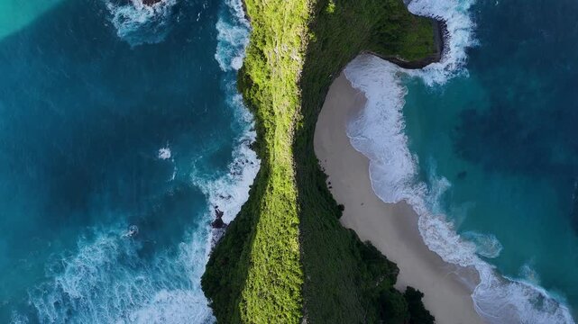 Nusa Penida vertical cliff with beach cove and ocean aerial view Bali