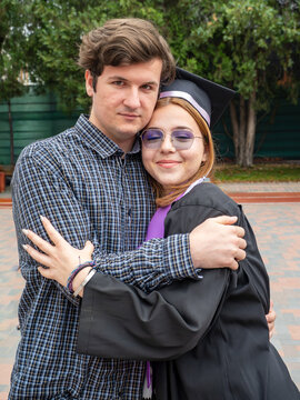 Brother hugging his graduate sister