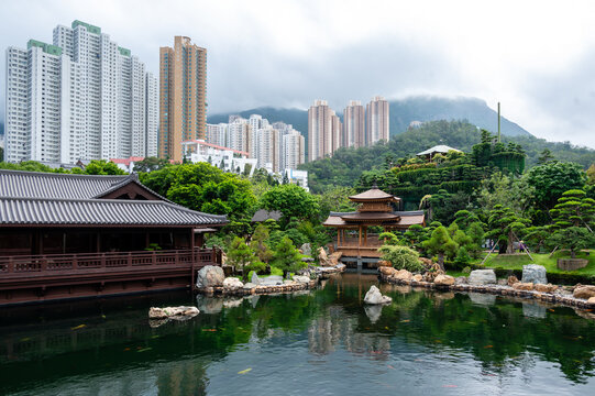 Traditional wooden pavilions and scenic koi pond at Nan Lian Garden contrasted with high-rise apartments in Hong Kong