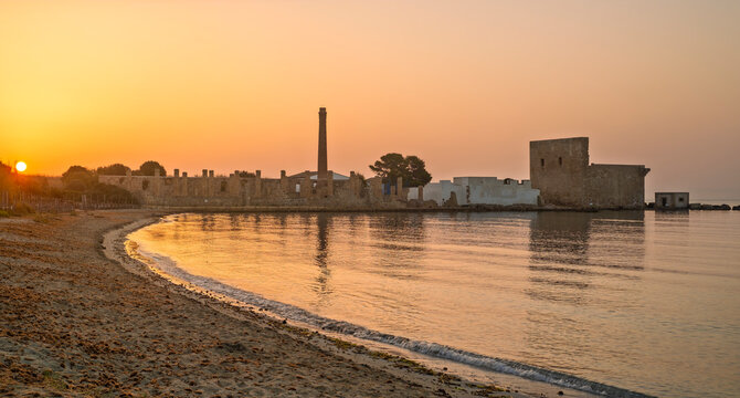Dawn light on the ruins of the old factory for the processing of tuna and of the medieval watch tower at Vendicari, Syracuse, Sicily, Italy.