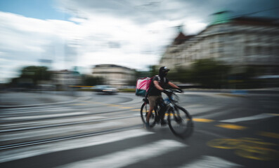 Naklejka premium Food Delivery Bicyclist Rides Fast Along A Bike Path City In Motion Rushing By In A Blur