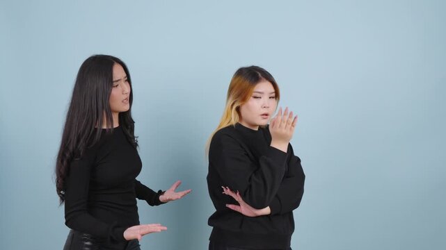 Young woman apologizing to her upset friend after an argument