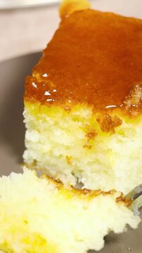 woman preparing an Glazed Gourmet rhum baba cake on Plate With Measuring Spoons, Flowers and Cozy Table Setting