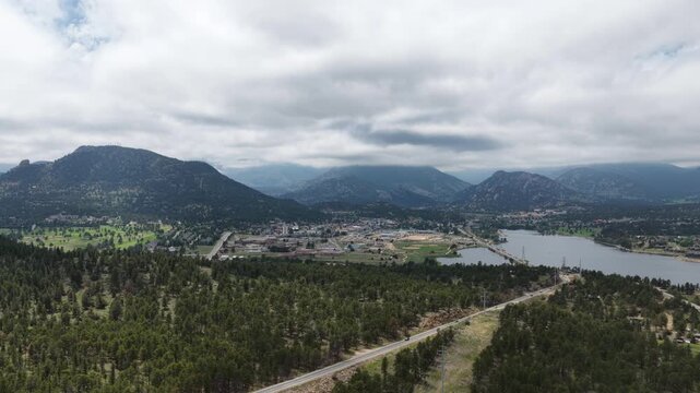 Wide aerial of Lake Estes and Estes Park Colorado in summer with dense forest and cloudy sky