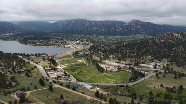 Wide aerial of Estes Park Colorado in summer along Lake Estes in scenic mountain valley next to Rocky Mountain National park with cloudy sky