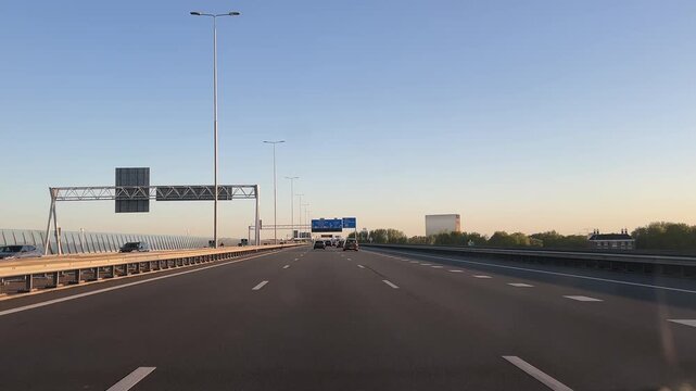 Amsterdam Netherlands highway, Evening highway traffic beside a modern bridge tower