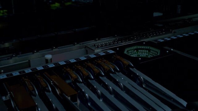 Close-up of high-speed automated machine sorting and assembling components for an electronic device.High-precision robotic arm picking micro components under bright optical inspection strobe flashes.