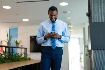 Fototapeta premium African american businessman using smartphone in modern office