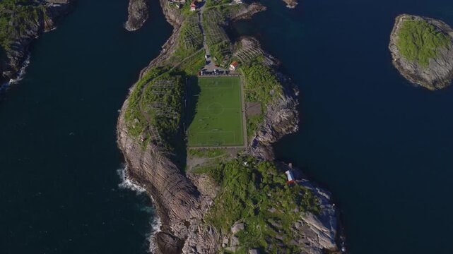 Aerial drone view of football pitch on Lofoten island surrounded by ro