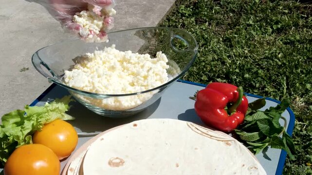 the process of cooking pita bread with cheese yellow tomatoes in sunlight cooking pita bread for lunch. High quality 4k footage