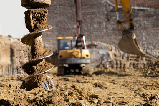 Auger drill bit pulling out soil at construction site