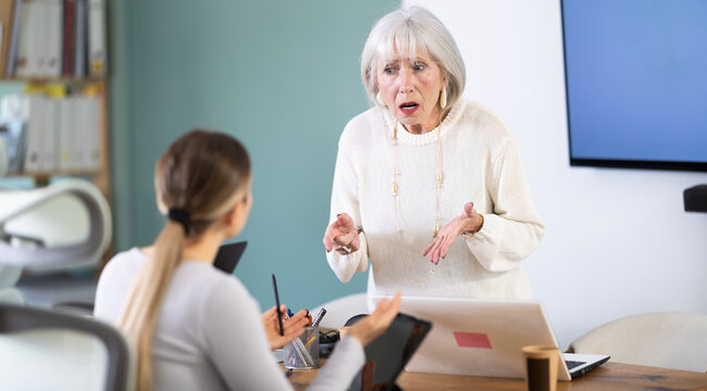 Woman does not cope with her work duties at tablet, and employee is reprimanded by her mature superiors. Mentor shouts and is indignant at subordinate, reproaches for her lack of professionalism.