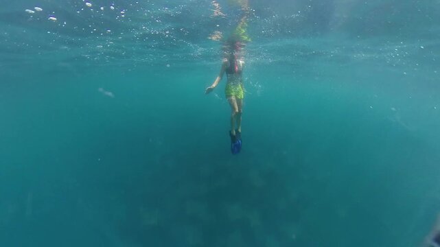 360 underwater footage of a female diver descending above a massive swirling school of mobula rays in Baja California Sur, creating an unforgettable wildlife encounter in crystal-clear blue water.