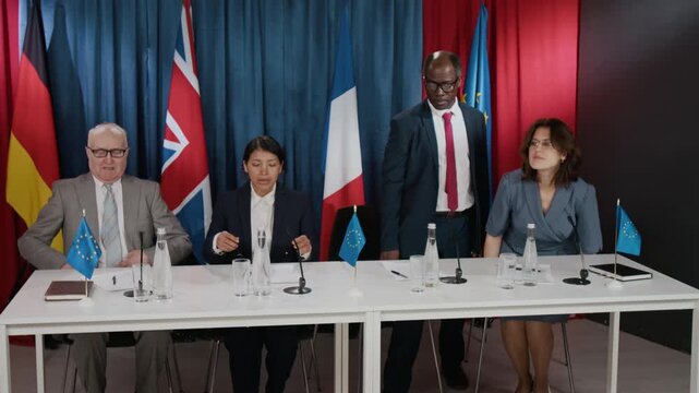 Diverse international delegates taking seats at conference table with flags during summit. Video suits commercial projects on global politics, diplomacy, and corporate governance