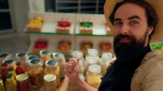 Man films vlog praising hidden gem sustainable local neighborhood supermarket, impressed by high quality vegan products. Healthy living lifestyle influencer shows around newly opened zero waste shop.