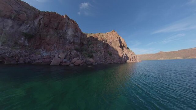 360 camera view of the dramatic cliffs of Espiritu Santo Island with crystal-clear turquoise water on a sunny day, captured in an immersive ultra wide-angle perspective.