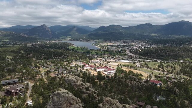 Aerial of Estes Park town view overlooking the valley and Rocky mountains in Colorado with dense forested areas and Lake Estes