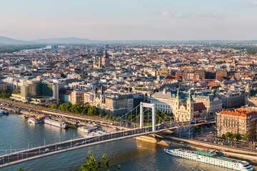 Fototapeta premium A panoramic view of Budapest from Gellért Hill, overlooking the Danube River and the Elizabeth Bridge. The Elizabeth Bridge is an elegant white suspension bridge 