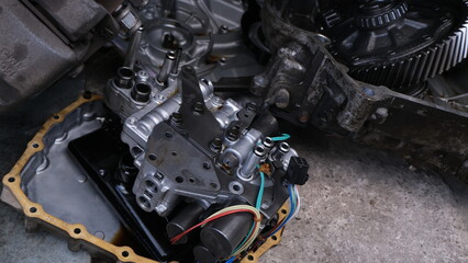 Fototapeta premium Honda Brio CVT automatic transmission repair process at an automotive workshop. Displays disassembled components for inspection and service.