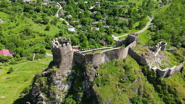 Top oblique aerial view of Atskuri Fortress in Georgia, showing the defensive towers, stone walls and elevated position of the medieval ruins.