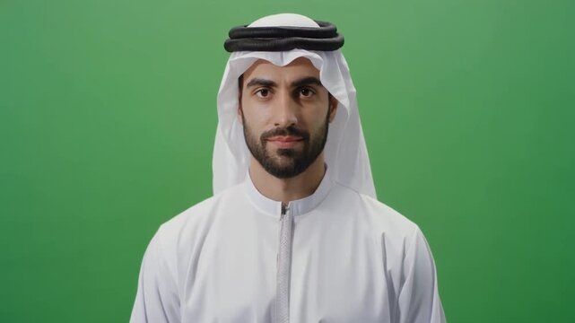 Portrait of a young Arab man wearing traditional clothing against a green screen.