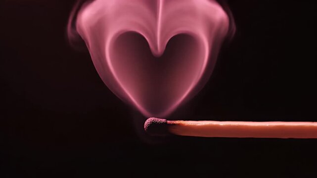 Close-up of a single lit wooden match igniting a small flame in darkness, capturing warm glow and tiny smoke