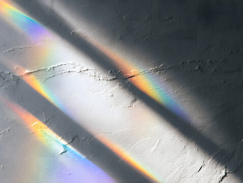 Luxury wellness branding involves abstract patterned light flow and rainbow refraction on a neutral textured wall.