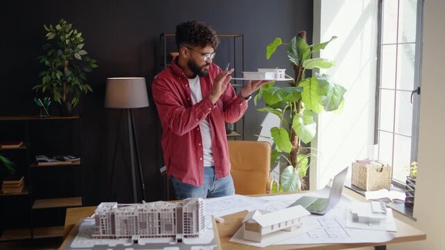 Architect lifts house model during focused studio design review