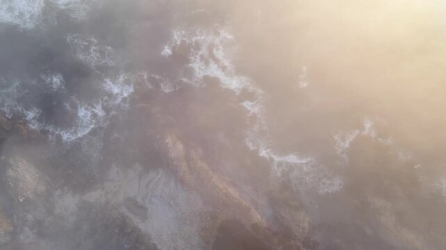 Aerial shot of the rugged coastline covered in fog at dawn along the Pacific Ocean south of Monterey California