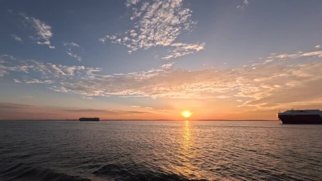Car Carrier Ship on Calm Sea at Sunrise with Dramatic Clouds