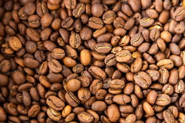 Fototapeta premium Background filled with perfectly roasted Arabica coffee beans, capturing the aromatic essence and rich coffee tradition of Colombia.