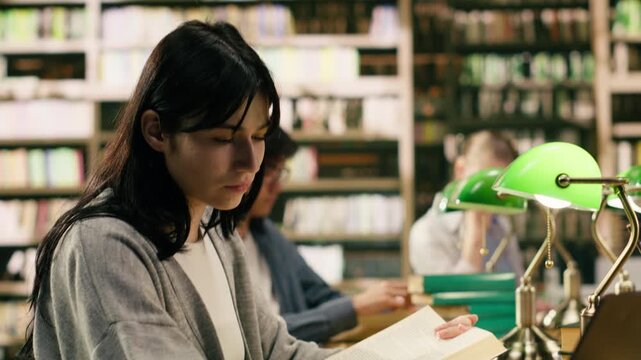 Young adult drinking coffee and taking notes on laptop from open book, focused student using study materials for exam preparation, Independent study with drink, with study session and coursework.