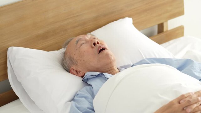 ベッドで眠る口呼吸の高齢者の男性