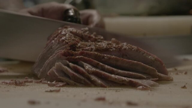 Handheld slicing seasoned steak into thin tender pieces