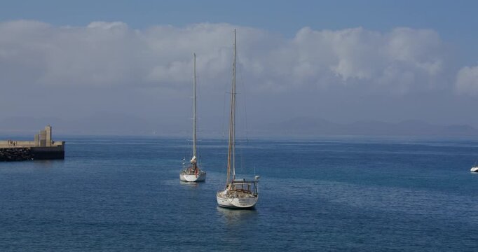 Two sailboats moored up outside Deportivo Rubic&oacute;n marina at Playa Blanca