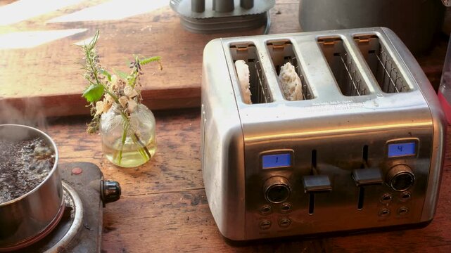 English muffin popping up from a stainless steel kitchen toaster
