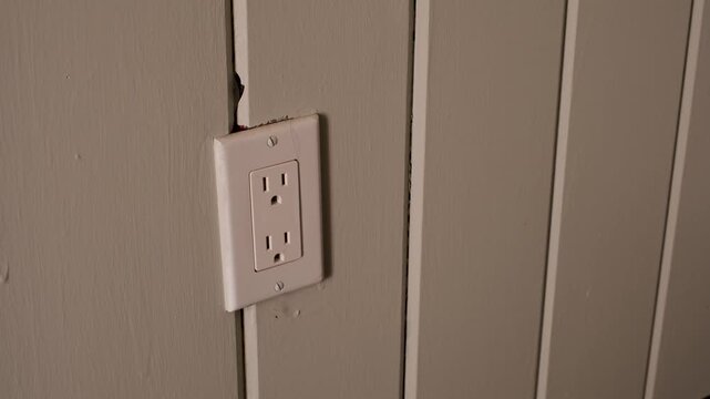 pulling a blue charger block out of a wall socket